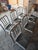 A set of six, authentic Emeco chairs in brushed aluminum, purchased in the 2010s. Chairs all have blue/green seat pads....