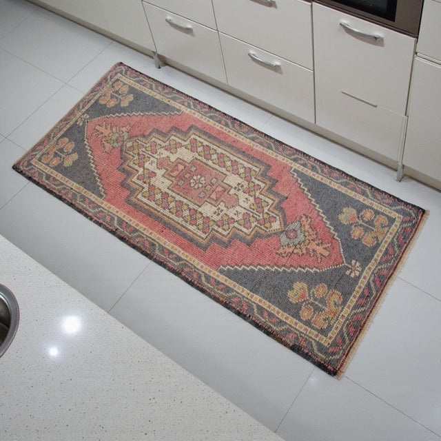 This authentic hand-knotted Tashpinar rug features a striking geometric medallion and a weathered, sun-faded aesthetic....
