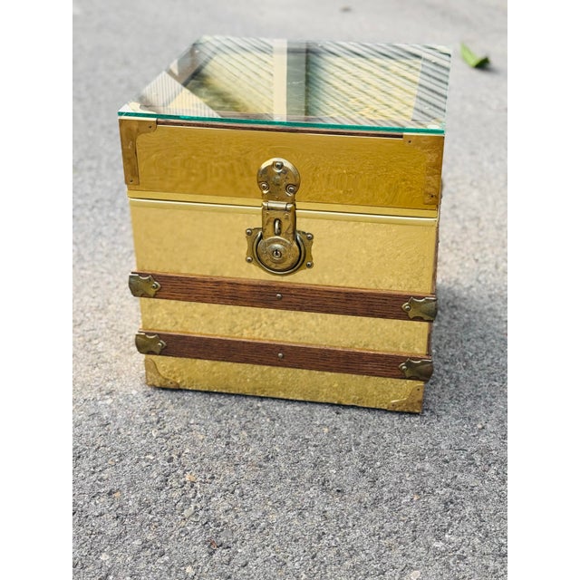 This stunning vintage brass and glass trunk is both a functional storage piece and a striking decorative statement side...