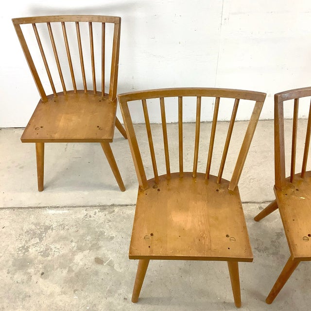 This set of four spindle back dining chairs by Leslie Diamond for Conant Ball brings the quiet confidence of classic mid-...