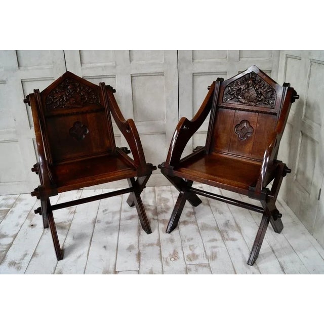 A stunning pair of oak glastonbury chairs with hand-carved inscription “esperang” meaning wait carved into the back,...