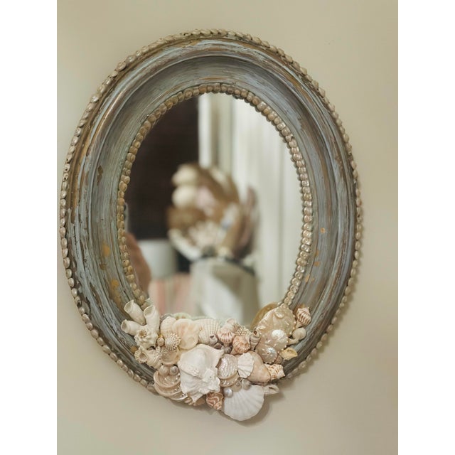This is a lovely oval mirror. Painted a light blue, the original gold finish shows through in places where the blue has...