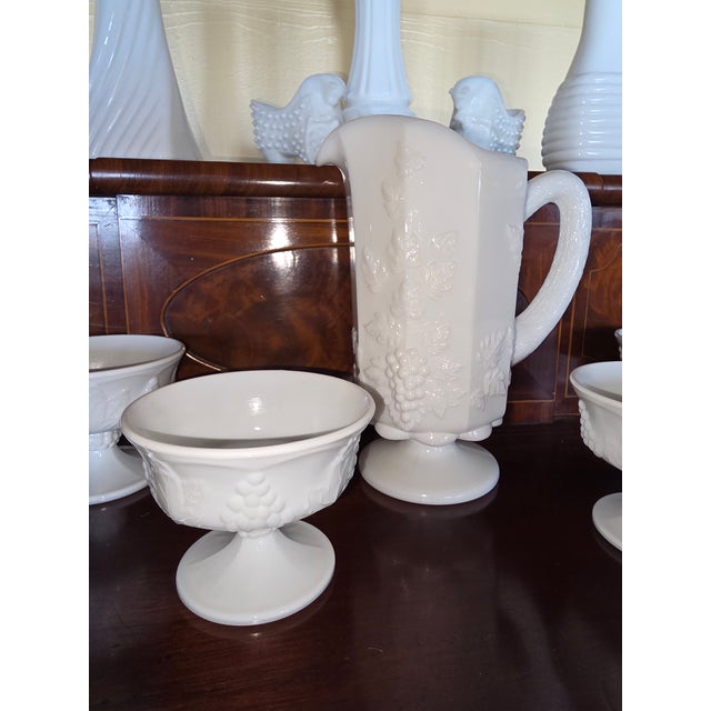 Collection of vintage milk glass. A pitcher, 4 dessert competes, three vases, and two shoes.