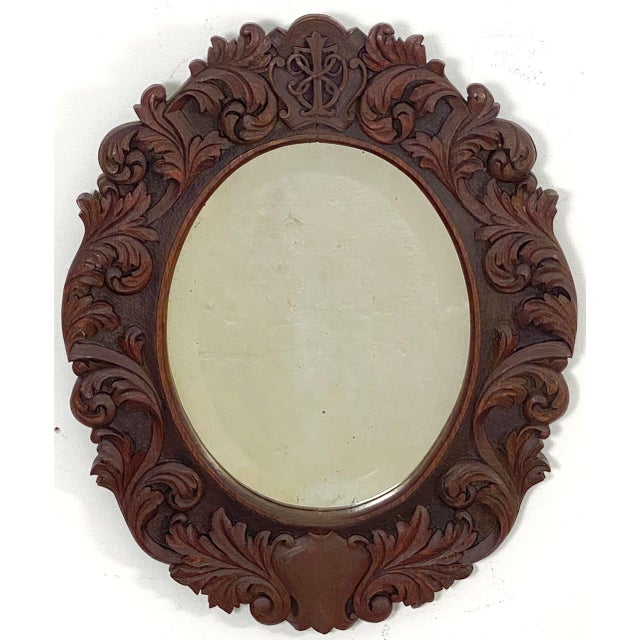 A fine Black Forest oval wall mirror from the late 19th century, featuring a decoratively carved frame with beautiful...