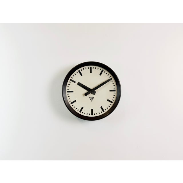 This wall clock was produced by Pragotron in former Czechoslovakia during the 1960s. It features a brown bakelite frame...