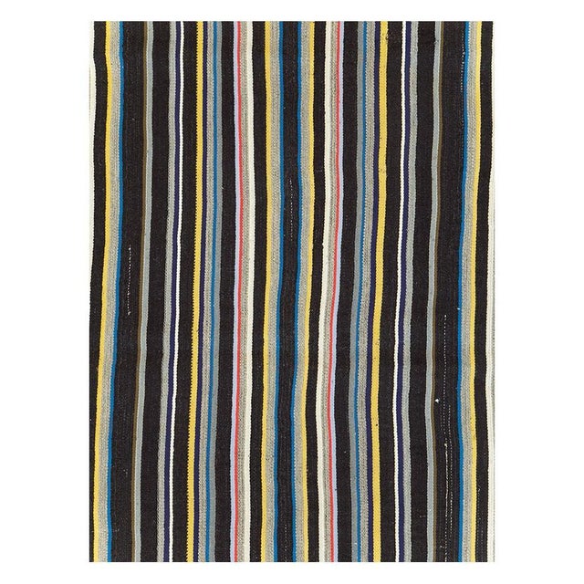 A vintage Turkish flatweave Kilim room size carpet handmade during the mid-20th century with a vertically striped...