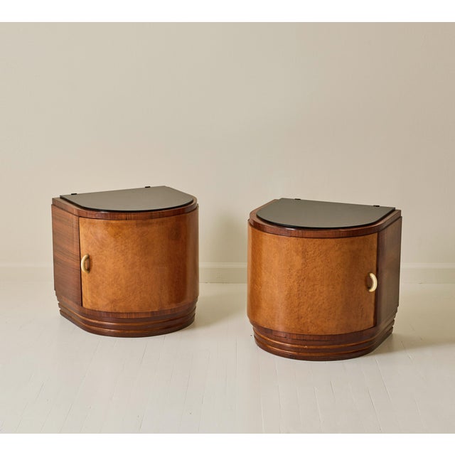 A pair of bedside tables, produced in Italy in the 1940s. Made with sycamore and veneered in burl wood, each piece...