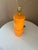 Vintage Mid-century Modern cylindrical table lamp in orange. Includes harp and finial 23" tall from bottom to top of socket.