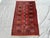 This hand-knotted Khal Mohammadi runner features a single column of octagonal guls down the center field, flanked by rows...