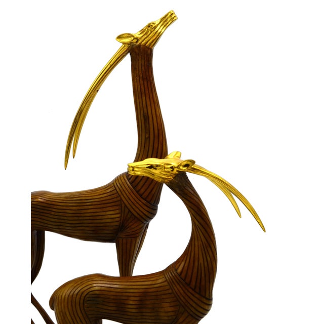 A Pair of wooden Gazelles mounted on a base. The heads are made out of brass. Both are marked. Dimensions smaller Gazelle:...