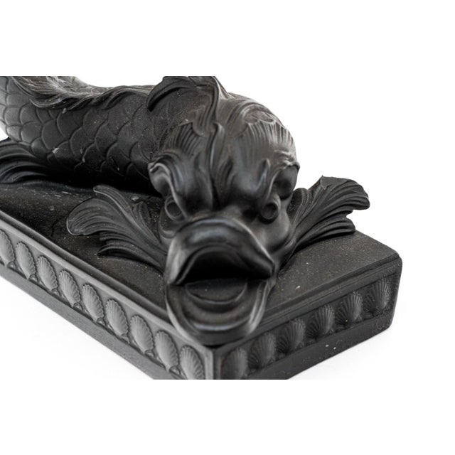 Pair Wedgwood basalt dolphin form candlesticks with gilt rococo foliate candle nozzles. The dolphins boldly modeled and...