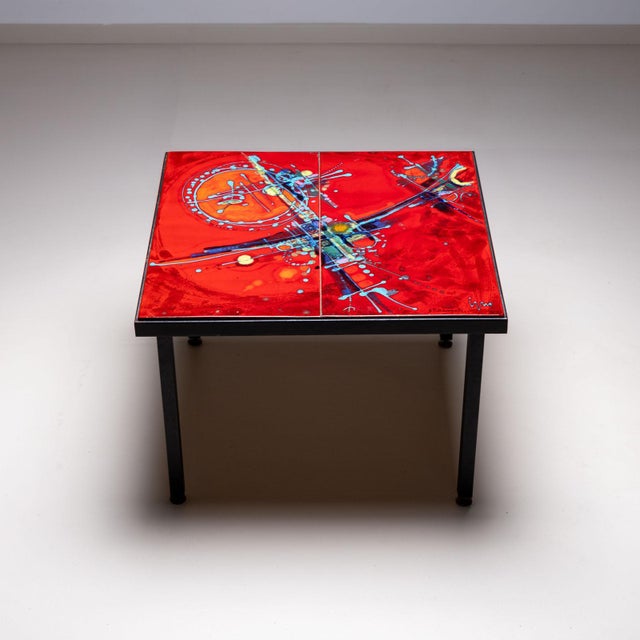 Square side table on a black iron frame and red glazed ceramic tiles with abstract polychrome decoration. The tiles are...