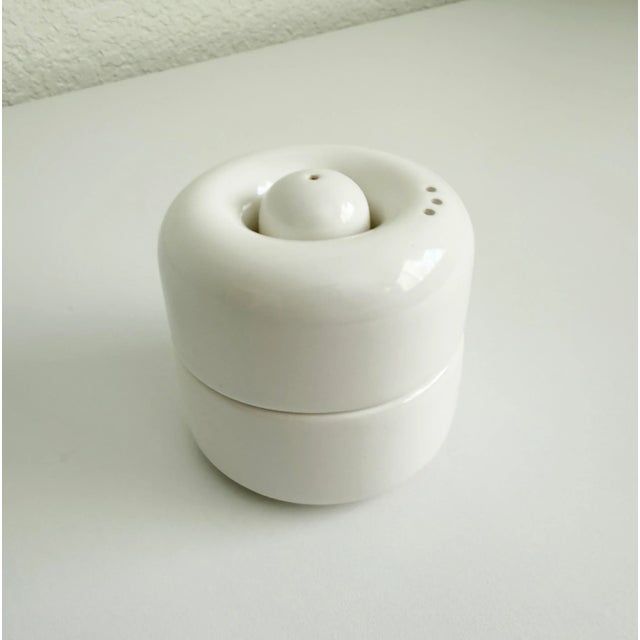 A pair of stacking salt and pepper shakers made of ceramic with a white gloss glaze finish. Retains the original plastic...