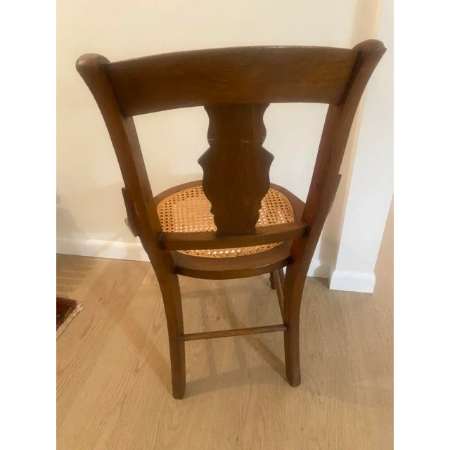 Walnut chair with burled inlay design on the back. Caned seat. Repaired damage on one of the 'arm' sides.