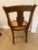 Walnut chair with burled inlay design on the back. Caned seat. Repaired damage on one of the 'arm' sides.