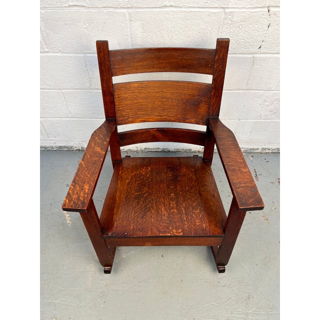 Classic Mission-style oak rocking chair crafted in the tradition of Stickley. Features solid oak construction, vertical...