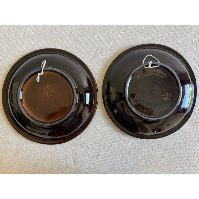 Pair of vintage 1970s, Swiss folk art ceramic wall Plates with 2 different, hand painted Hot Air Balloon motifs, one in a...