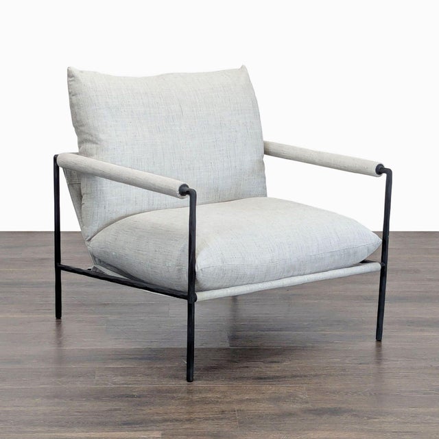 This Crate and Barrel chair features a sleek black metal frame with light, soft fabric cushions. The wide seat and tall...