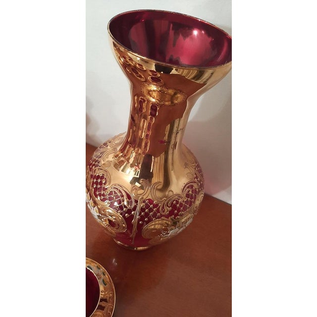 Blown and handcrafted glass, 24K gold finishes, porcelain decoration. Famous "Tre Fuochi" jug from the ancient Venetian...