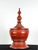 A traditional Burmese deep red three-piece lacquered offering urn with a tall turned finial, domed, spired lid, bulbous...