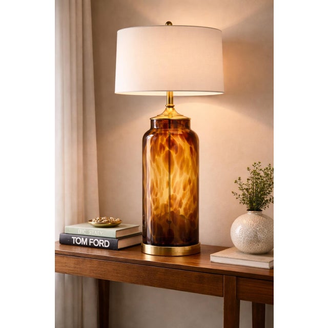 A bold vintage statement lamp featuring a tall cylindrical tortoiseshell art glass body with warm amber coloration and...