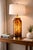 A bold vintage statement lamp featuring a tall cylindrical tortoiseshell art glass body with warm amber coloration and...