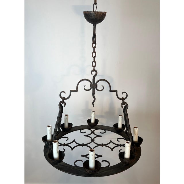 This round 8-light chandelier is made of wrought iron. It is a French Gothic-style work. Circa 1950