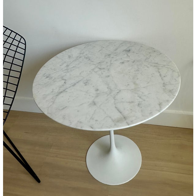 Round 20" Tulip side table designed by Eero Saarinen for Knoll. Executed in white Carrara Italian marble and cast iron...