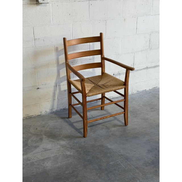 Beautiful vintage Danish armchair crafted in solid pine with handwoven rush seat and classic Scandinavian ladderback...