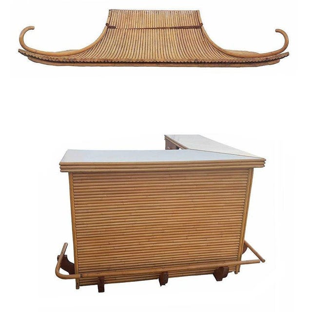 This mid-century vintage rattan bar with a Formica top, complete with a restored rattan tiki hut-style roof and eight bar...