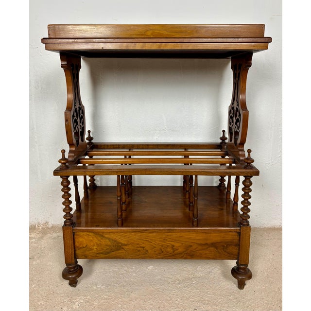 Elegant Victorian walnut Canterbury featuring a removable tray top, open slatted storage compartment, and a lower drawer....