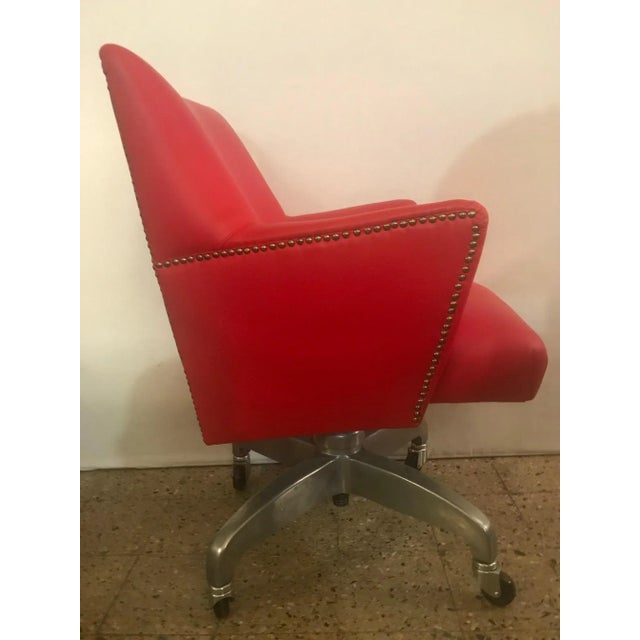This is a leather and aluminium office tilting armchair.