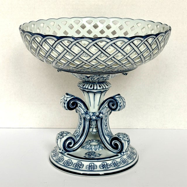 Elevate your home décor with this elegant Vintage Bombay Company Blue Reticulated Compote Pedestal Bowl. Featuring a...