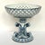 Elevate your home décor with this elegant Vintage Bombay Company Blue Reticulated Compote Pedestal Bowl. Featuring a...