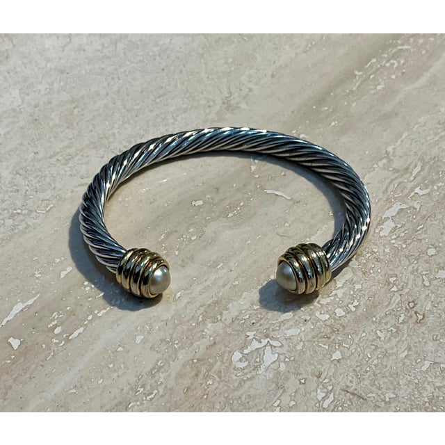 This vintage silver classic cable bracelet with pearl accents pairs timeless metalwork with the soft luster of faux...