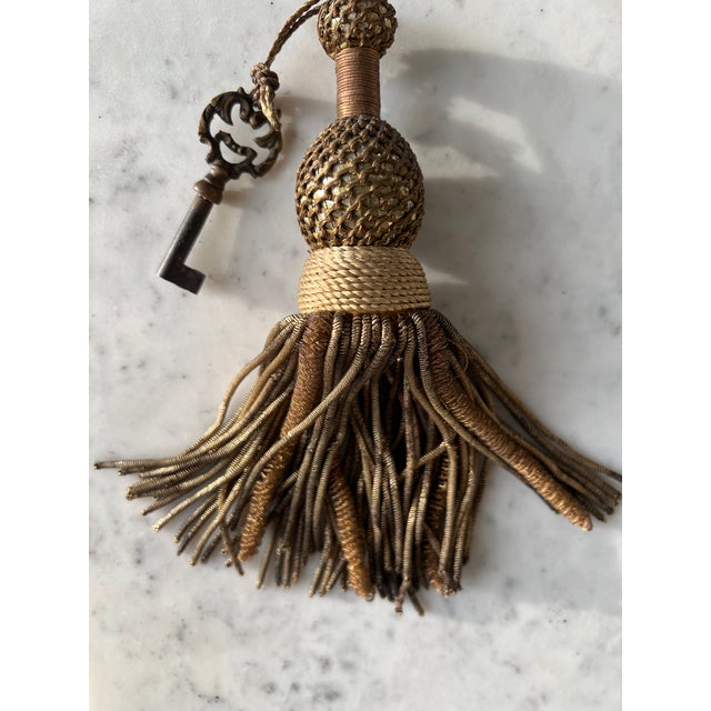 An antique French gold metallic tassel. often used to accent furniture knobs, drapery, or as a decorative fob for a...