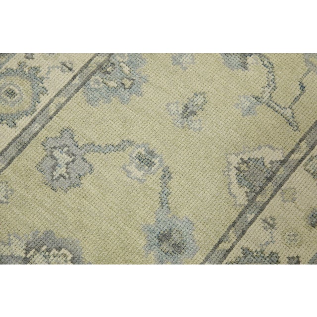 This modern Turkish Oushak rug is a stunning piece of art that has been handwoven using traditional techniques by skilled...