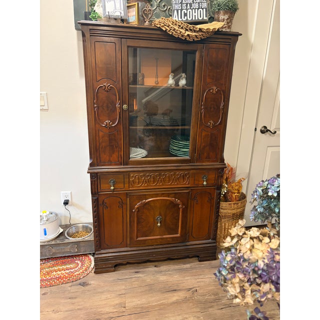 Beautiful vintage display cabinet crafted in richly finished wood with elegant carved detailing throughout. This piece...