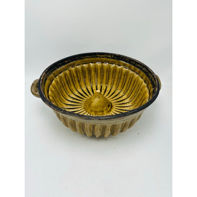 This is a vintage ceramic bundt cake mold / tube pan, used for baking ring cakes. It has a fluted, scalloped interior and...