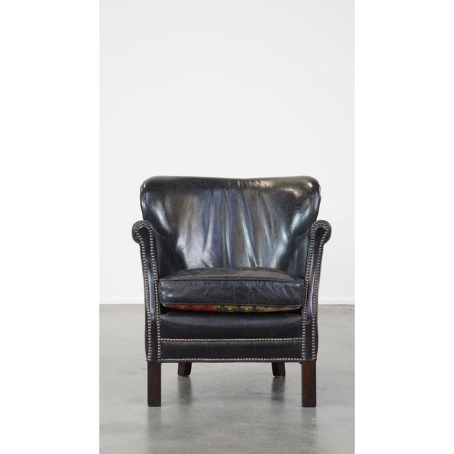This subtle black armchair with reversible Kelim seat cushion. This nice cowhide armchair is comfortable to sit on despite...