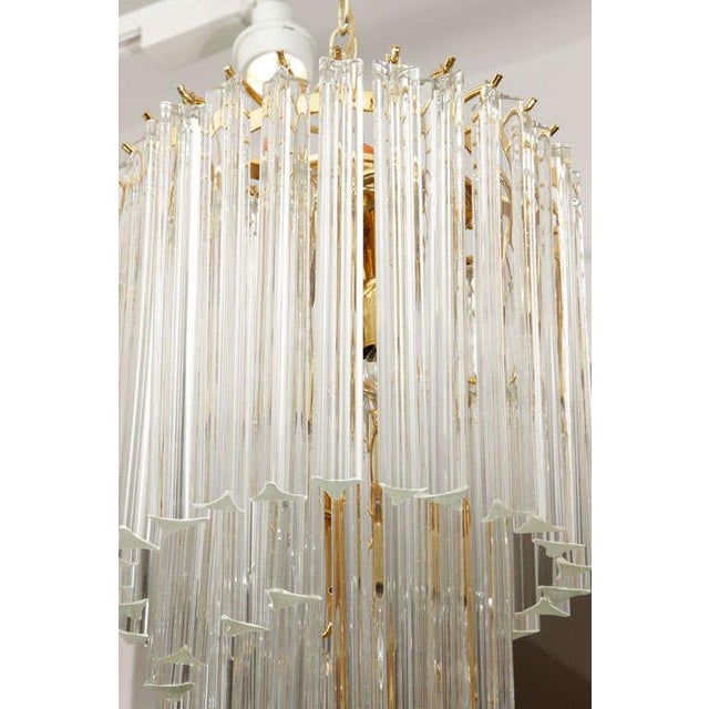 A very glamorous five-tier Murano glass foyer chandelier on a brass frame.