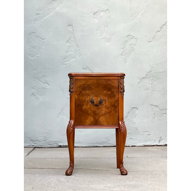 French Louis XV–style bedside cabinet, early 20th century, featuring elegant cabriole legs, carved detailing, and a...