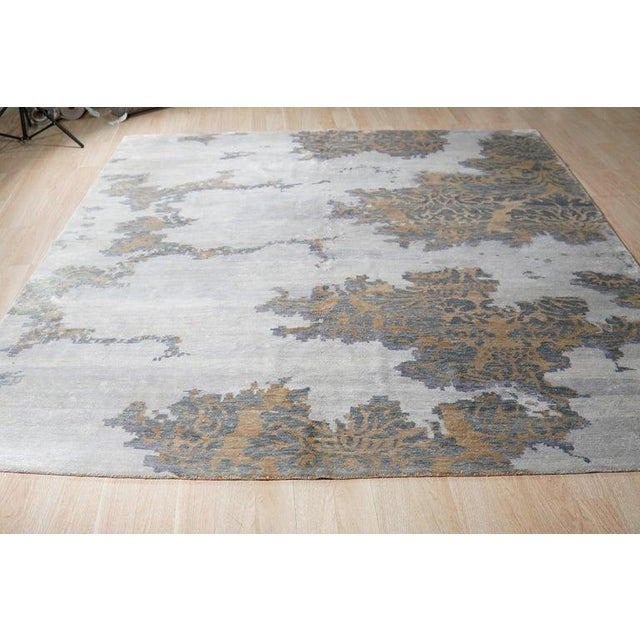 This hand knotted pile rug is crafted from a blend of wool and bamboo silk. The primary gray color serves as a neutral...