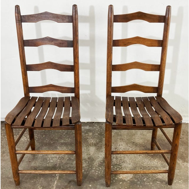 Vintage pair of ladderback dining or occasional chairs with slatted seats. Rich natural finish and classic shape. Unique...