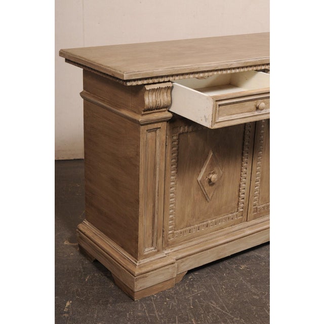 An Italian wooden credenza, with nicely trimmed details, from the 20th century. This vintage buffet cabinet from Italy has...