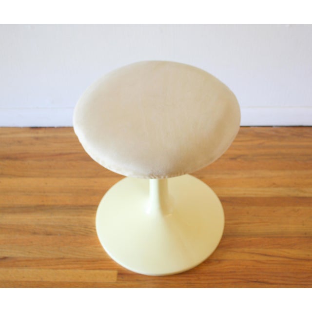 This is a mid century modern Eero Saarinen style vanity seat stool that has the iconic tulip base, and an upholstered seat...