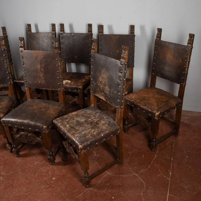 This set of eight renaissance-style walnut folder chairs, with backrests embellished with side flames and upholstered in...