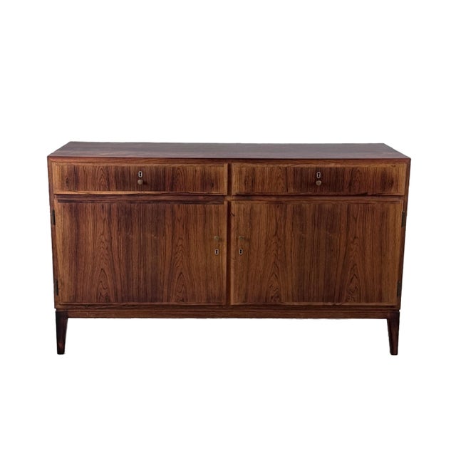 A beautiful rosewood grain detail enhances the rich wood patina of this vintage storage piece. Masterfully crafted in...