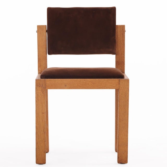 French Brutalist-style oak side chairs, circa 1960, featuring boldly constructed frames and fully tilting backs. The...