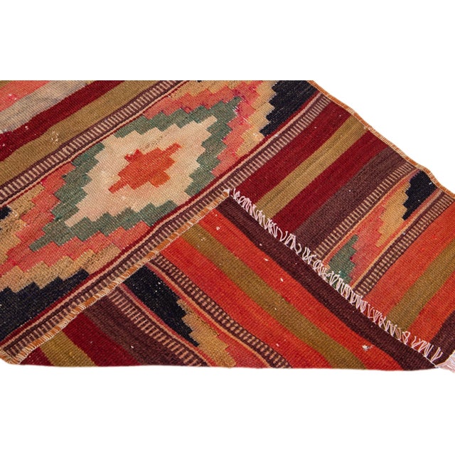 Beautiful vintage Turkish Kilim hand-knotted wool rug with a rust field. This piece has multicolor accents in an all-over...
